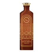 Organic Ron Gran Chaco Paraguay rum in a frosted amber bottle with gold cap and intricate Art Deco-style geometric patterns featuring a radiating 'G' logo and tribal motifs in gold on brown glass
